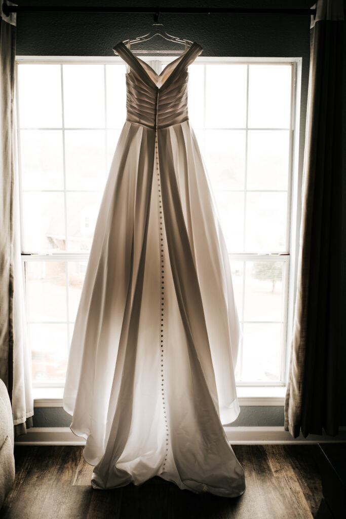 white wedding dress hanging in a window