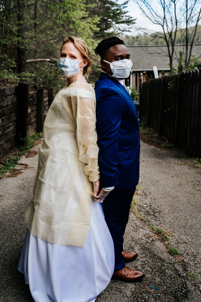 Bride and groom in mask and gloves and medical gear holding hands