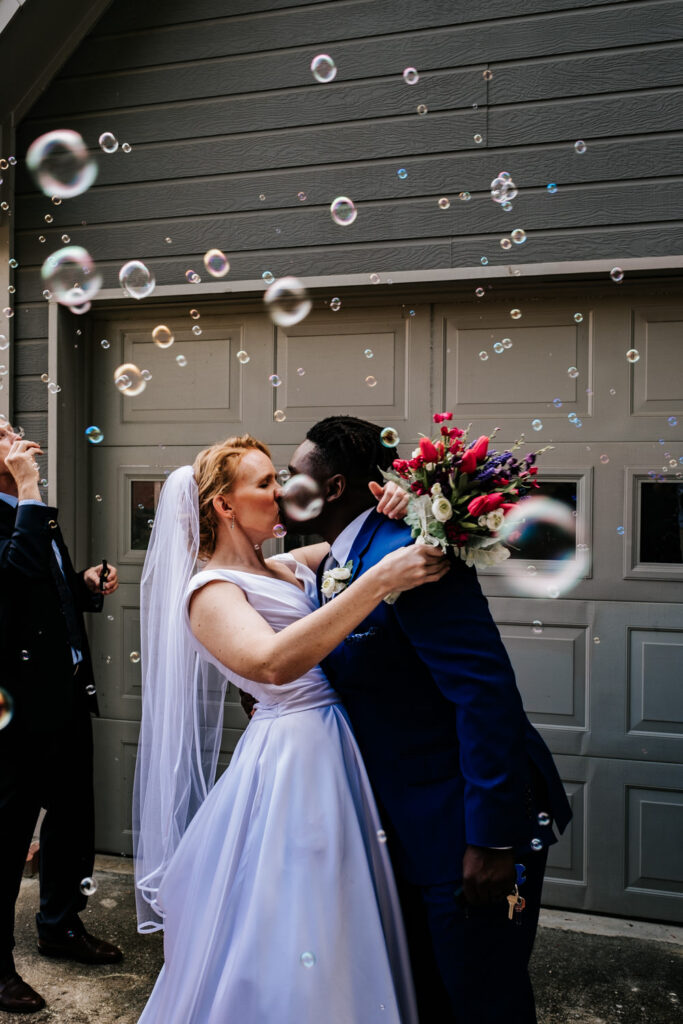 bride and groom kissing exit with bubbles