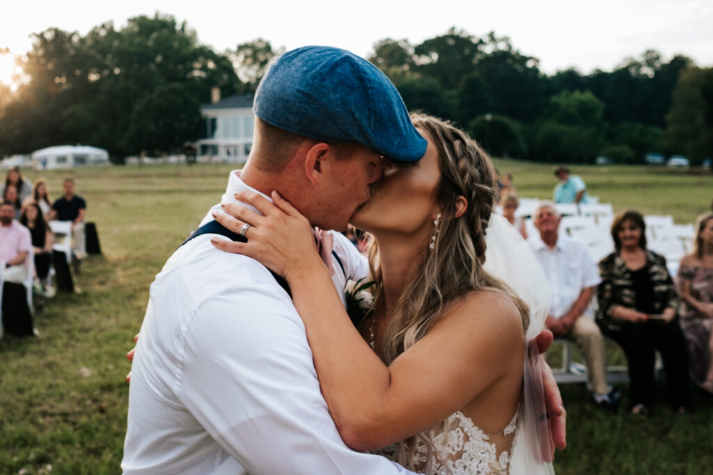 first kiss during ceremony with crowd in the background