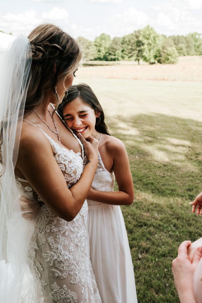 Bride hugging her daughter while daughter is crying
